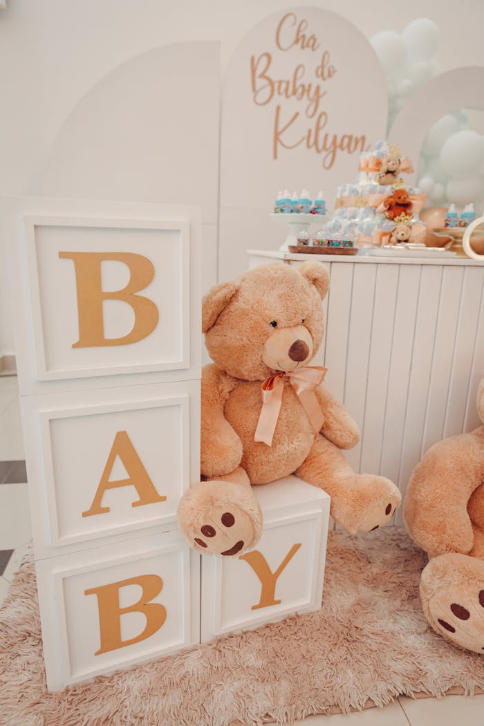 Charming baby shower decor featuring a large teddy bear and alphabet blocks spelling 'BABY'.