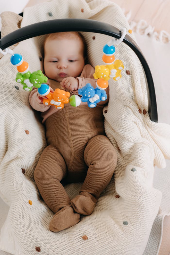 Adorable baby enjoying playtime with vibrant toys on a soft blanket indoors.