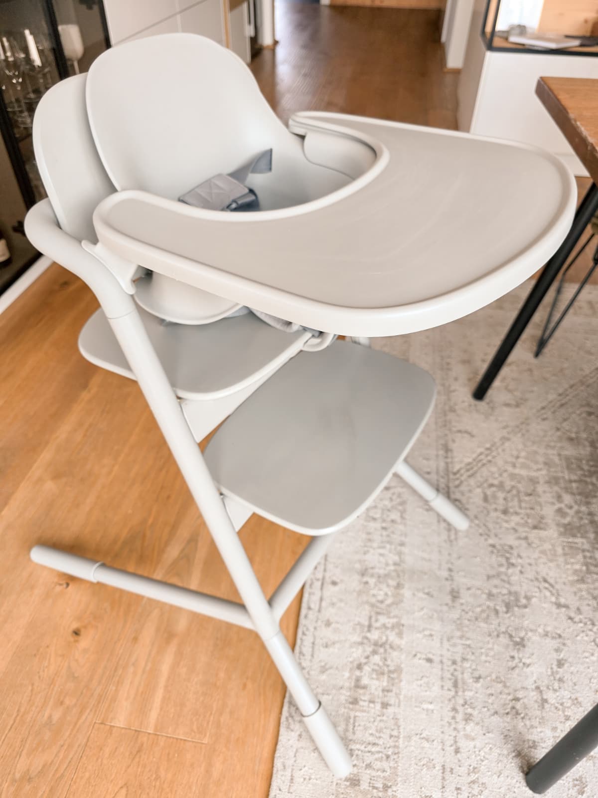 Moderner, hellgrauer Hochstuhl von Cybex auf hellem Holzfußboden und farblich passendem Teppich, mit Tablett und ergonomischer Sitzfläche – ideal für Baby-led Weaning und mitwachsendes Design.